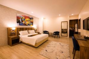 a hotel room with a bed and a desk and a desk at Jalo Hotel - Shashemene in Shashemenē
