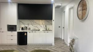 a kitchen with white cabinets and a black refrigerator at Ballarat home in Ballarat