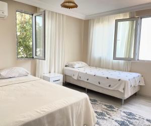 a bedroom with two beds and two windows at Mavi Apart in Demre +25 photos