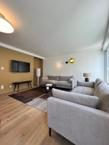 a living room with two couches and a flat screen tv at Maison Hyper-centre Dinard - Garage privé - 200 M plage in Dinard