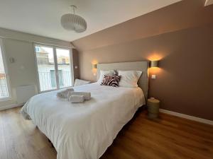 a bedroom with a large bed with two towels on it at Maison Hyper-centre Dinard - Garage privé - 200 M plage in Dinard