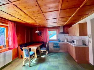 a kitchen with a wooden ceiling and a table and chairs at Haus Leo in Kappl