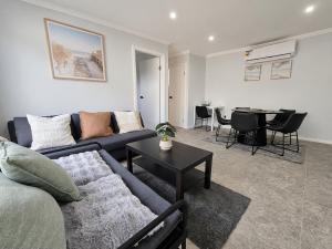 a living room with a couch and a table at Matildas Urban Escape 6-Min Station & Shops in Campbelltown South