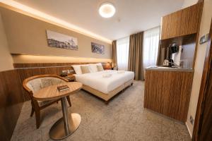 a hotel room with a bed and a table at Hotel Vaka in Brno +15 photos