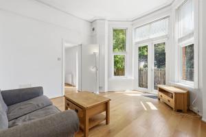 a living room with a couch and two windows at Madeley Oak in Ealing +9 photos