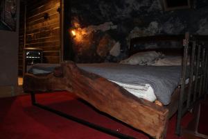 a wooden bed in a room with a wooden log at Chata LEA in Ratkovské Bystré