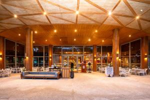 a large building with tables and chairs and lights at Andaman Pool Villas, Maikhao Beach Phuket in Mai Khao Beach