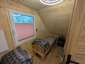 a small room with a bed and a window at Domki Przydwórz in Przydwórz