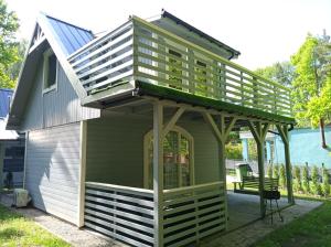 a house with a deck on top of it at Domki Przydwórz in Przydwórz +18 photos
