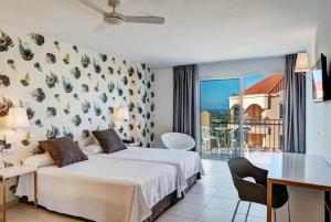 a hotel room with two beds and a balcony at Mirador Maspalomas by Dunas in Maspalomas