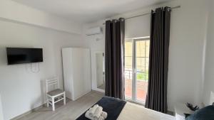 a living room with a large window and a tv at Amel's Apartments Comfortable Family Stay Near Orikum Beach in Orikum