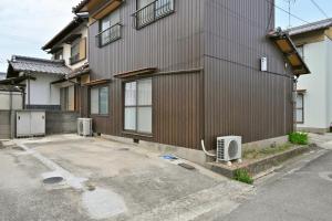 a building with a parking lot in front of it at Shion 潮音 in Sakaide