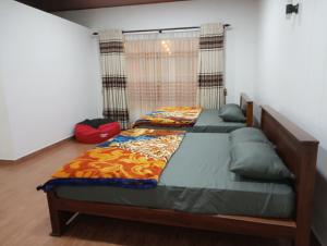 two twin beds in a bedroom with a window at Siriliya Homestay - Foreign Tourists Only in Nuwara Eliya +9 photos