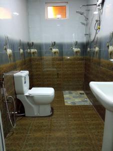 a bathroom with a toilet and some deer on the wall at Siriliya Homestay - Foreign Tourists Only in Nuwara Eliya