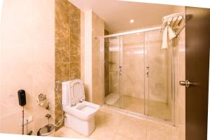 a bathroom with a toilet and a walk in shower at Jalo Hotel - Shashemene in Shashemenē +14 photos