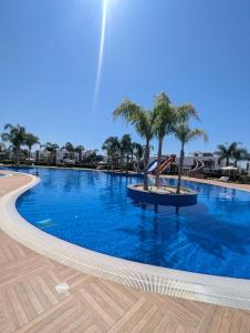 a swimming pool with palm trees in the middle at Your Four Seasons in Boghaz