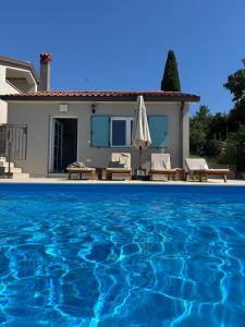 a villa with a swimming pool in front of a house at Casa Cavi Istria in Oprtalj