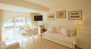 a living room with a couch and a table with chairs at Le Studio des Deux Frontières in Beausoleil