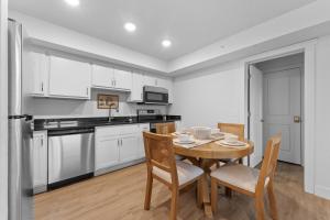a kitchen with white cabinets and a wooden table and chairs at RC403A- The Landing Lookout condo in Branson
