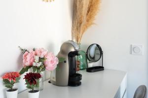 a kitchen counter with flowers and a coffee maker at Chambres D'hotes Le Cocon De Lily in Saint-Avit