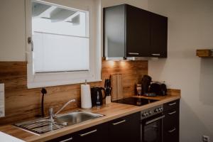 a kitchen with black cabinets and a sink and a window at Rheinwald in Weisweil