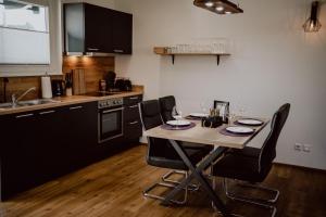a kitchen with a table and chairs in a kitchen at Rheinwald in Weisweil +12 photos