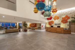 a lobby of a hotel with colorful chandeliers at Barceló Praia Cape Verde in Praia