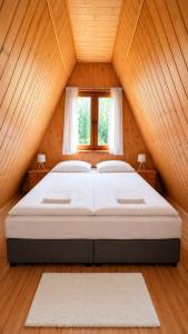 a bedroom with a large bed in a attic at Domki Bieszczady Siedlisko Harenda in Czarna