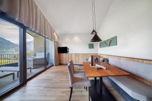 a dining room with a table and chairs and a balcony at Apartment Oberhaslerhof in Schenna
