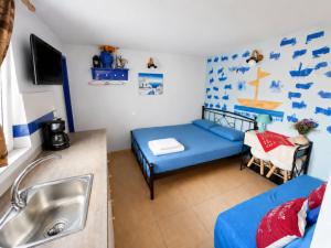 a room with a blue bed and a sink at 4 Seasons Island Suites Athens Airport in Markopoulo