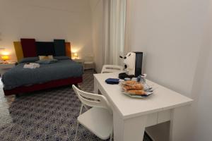 a room with a desk with a bed and a table with a plate of food at Maison Gadì in Maiori