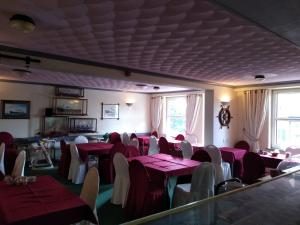ein Esszimmer mit roten Tischen und weißen Stühlen in der Unterkunft Glendower Hotel in Goodwick