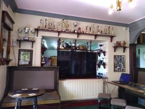 ein Zimmer mit einem großen Fernseher, einem Tisch und Stühlen in der Unterkunft Glendower Hotel in Goodwick