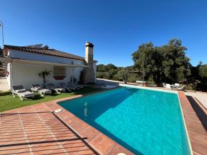 a villa with a swimming pool and a house at CORTIJO RURAL FLOR DE CAZALLA in Cazalla de la Sierra