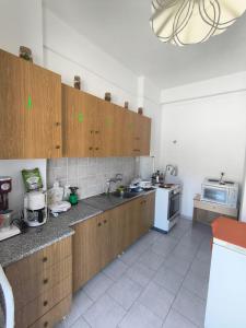 a kitchen with wooden cabinets and a sink and a microwave at Paradisos in Loutsa