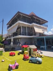 a building with a lot of play equipment in front of it at Paradisos in Loutsa