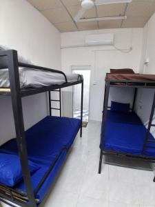 two bunk beds in a room with blue sheets at Coral Moon in Trincomalee