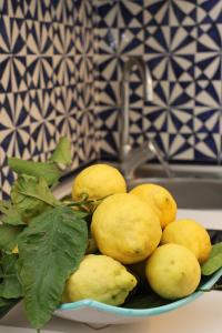 a bowl of yellow lemons on a counter with a sink at Maison Gadì in Maiori