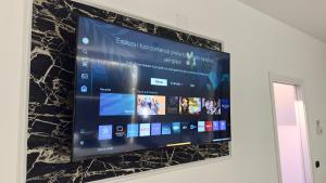 a large screen television hanging on a wall at B&B CORSO ROMA Room Suite & Spa in Apricena +142 photos