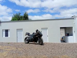 a motorcycle parked in front of a white building at Hotel New in Alegrete