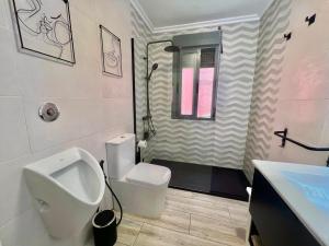 a bathroom with a urinal and a sink at Casa baja a la playa in Bueu +23 photos