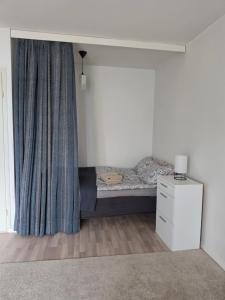 a bedroom with a bed with a curtain and a dresser at Linnankatu Apartment in Savonlinna