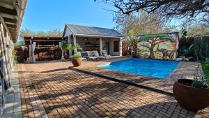 a backyard with a swimming pool and a house at The Serene Stay in Hoedspruit