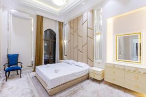 a bedroom with a white bed and a blue chair at Boulevard Residence Suite, 3 in Tashkent +52 photos