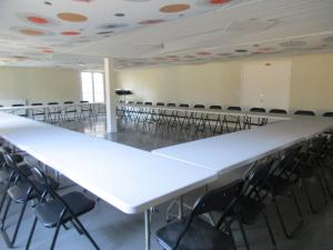 ルダンにあるLe Clos Albertの白い大きなテーブルと椅子が備わる空の部屋