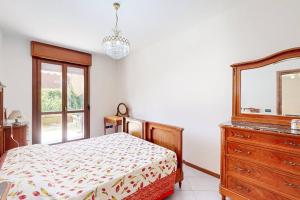 a bedroom with a bed and a dresser and a mirror at [BuenRetiro] Giardino, box e bici a disposizione in Acqui Terme