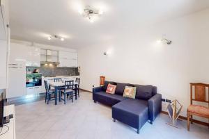 a living room with a couch and a table with chairs at [BuenRetiro] Giardino, box e bici a disposizione in Acqui Terme
