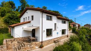 a white house with a stone wall at La Cuadra de San Pedro Ribadesella in Ribadesella