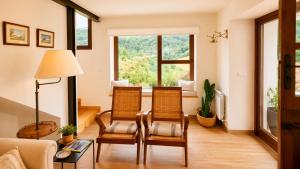 a living room with two chairs and a table at La Cuadra de San Pedro Ribadesella in Ribadesella