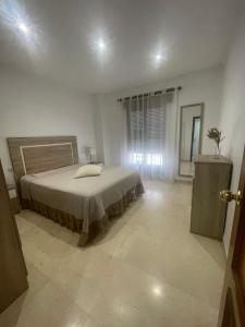 a bedroom with a bed in a white room at Apartamento CASA EL MORABITO in Puente Genil